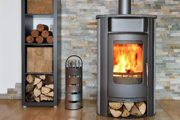 Ein Kamin mit Brennholz daneben.